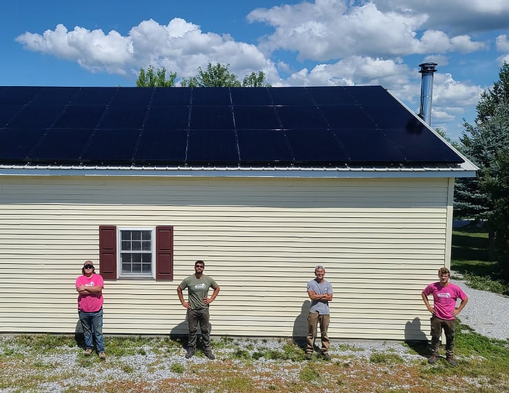 green mountain solar installers standing in front of solar panels on a roof in Vermont